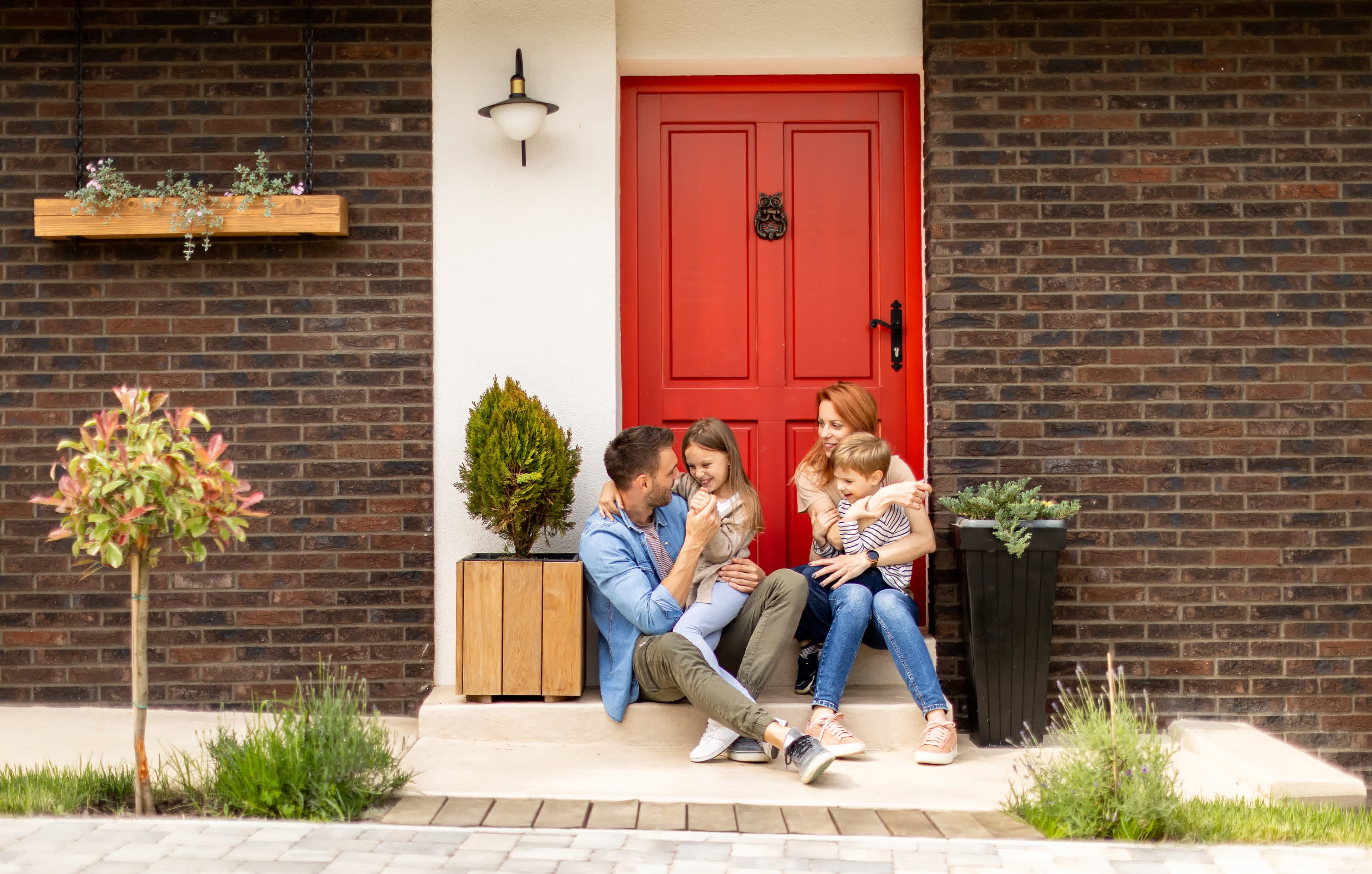 A family on the front steps of their home after an FHA streamline refinance