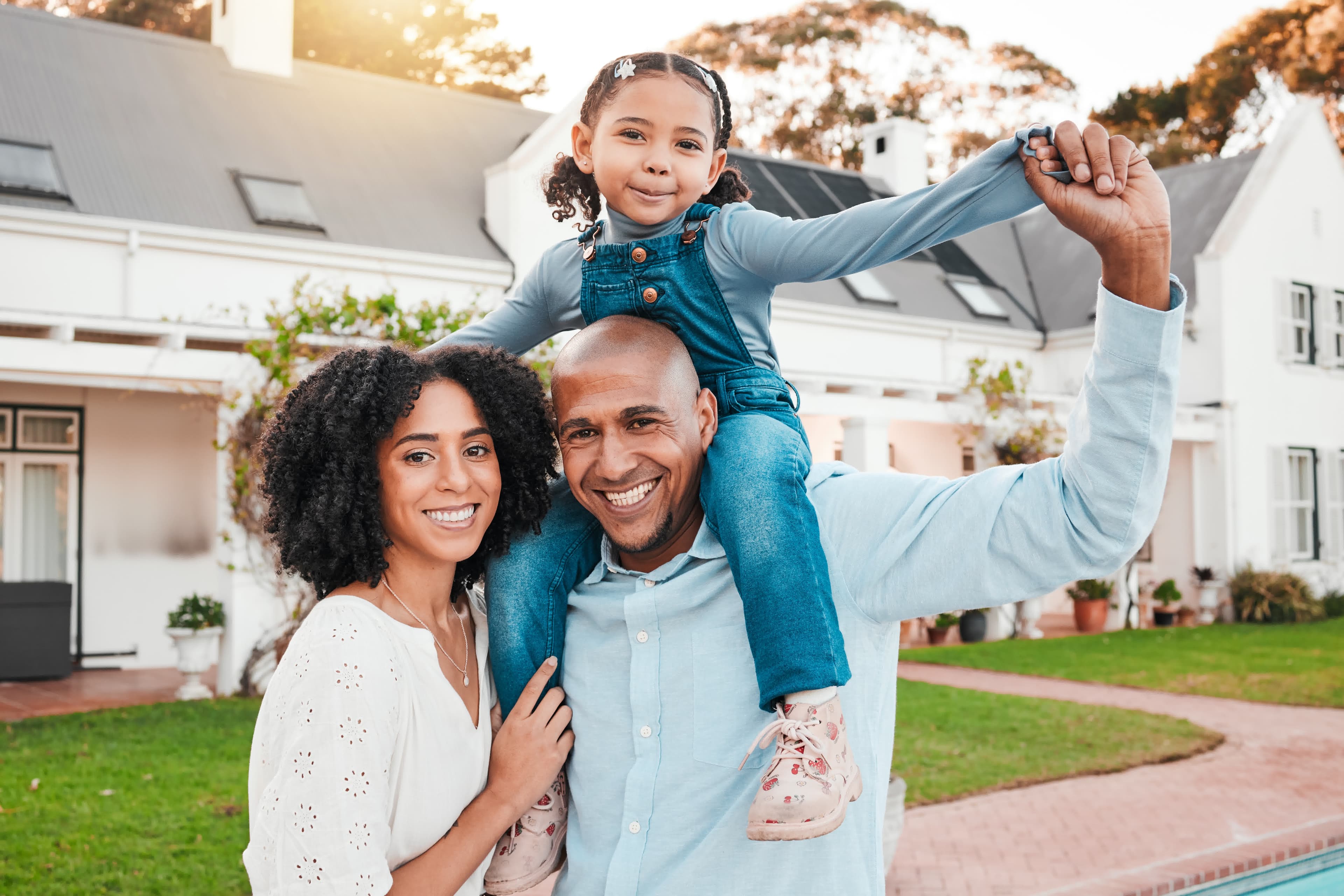 A family at sunset in front of their home shopping today's FHA rates