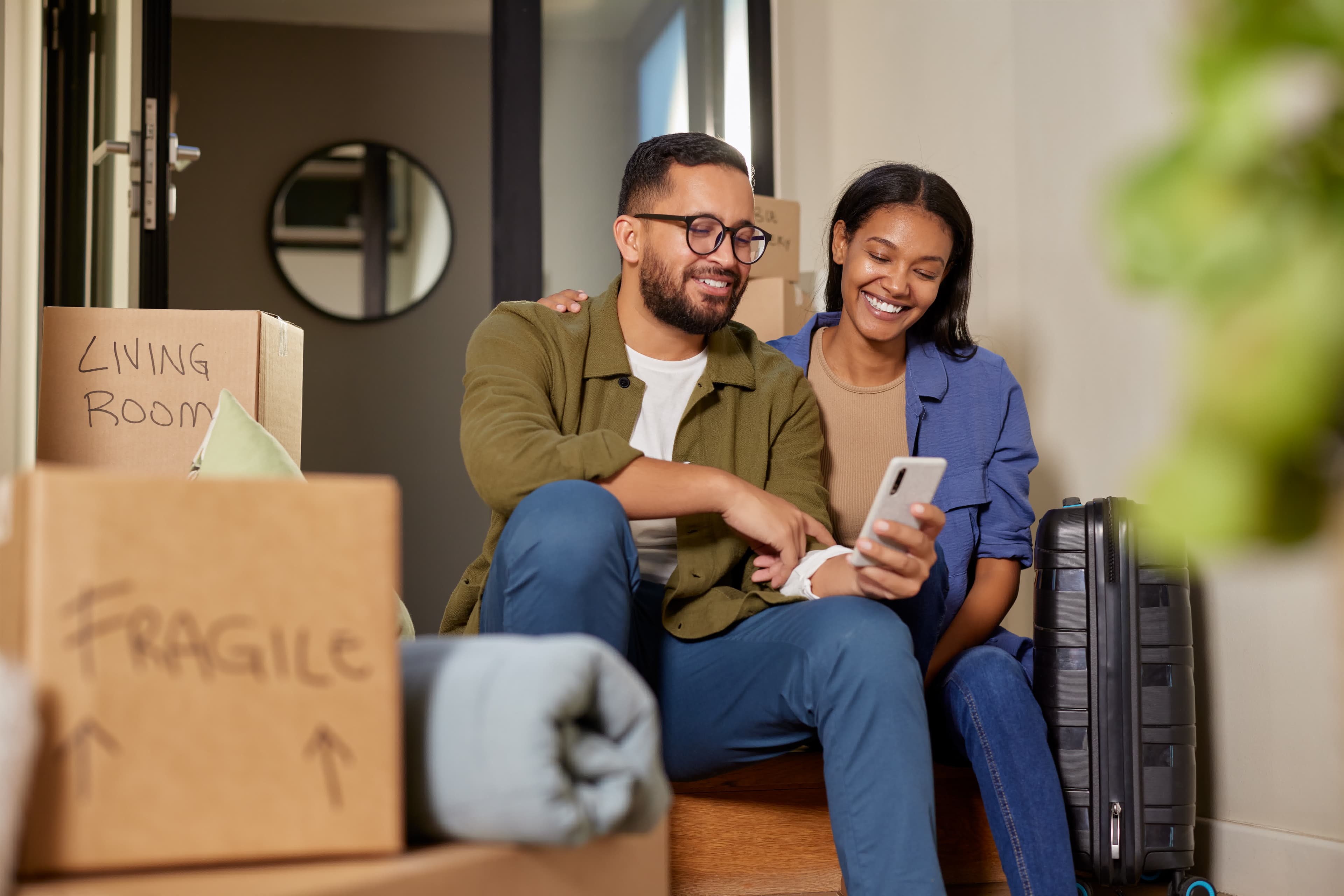 A young couple amid moving boxes after buying with a low down payment
