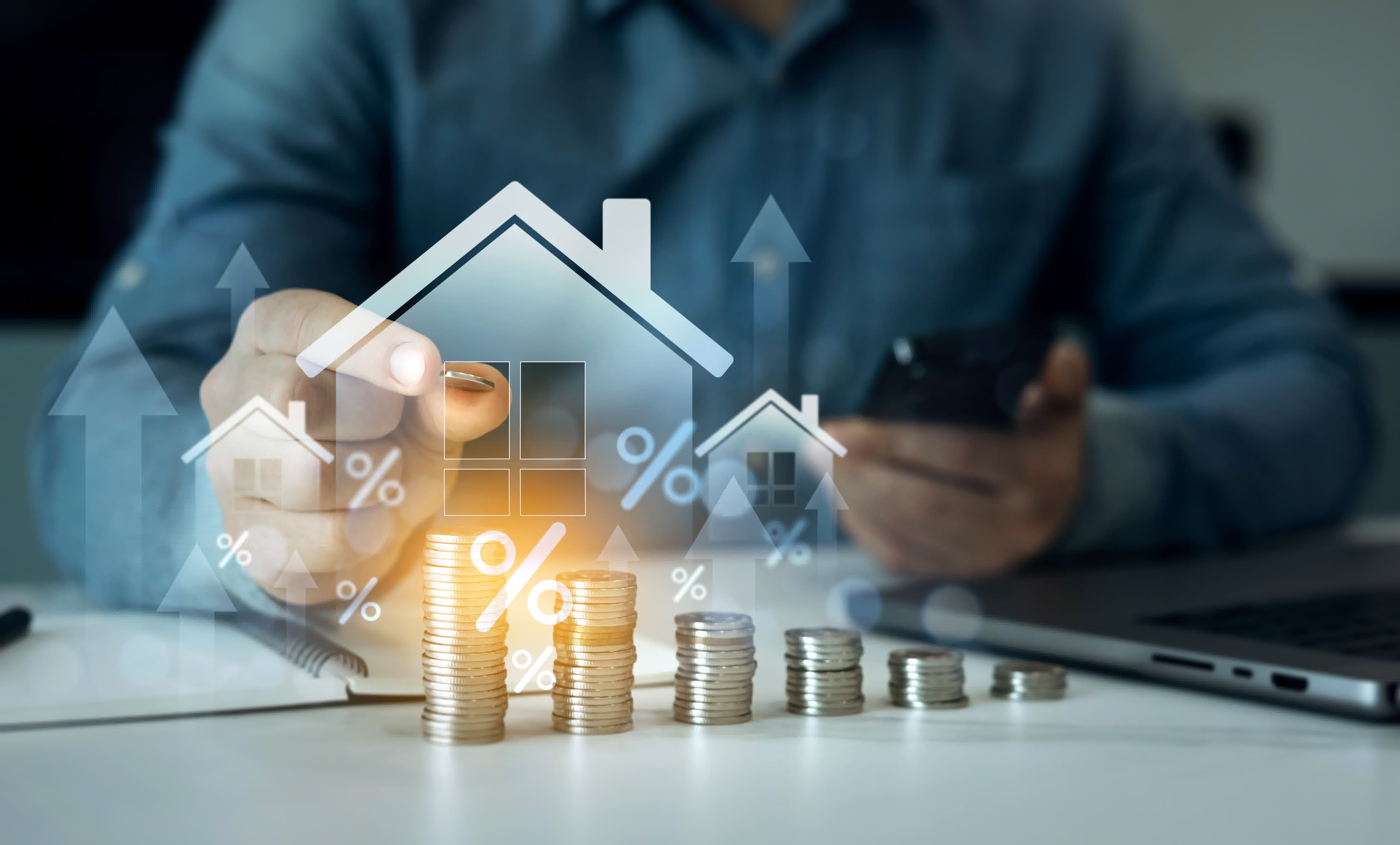 Rising house icons and percent signs over a laptop, illustrating locking versus floating a rate