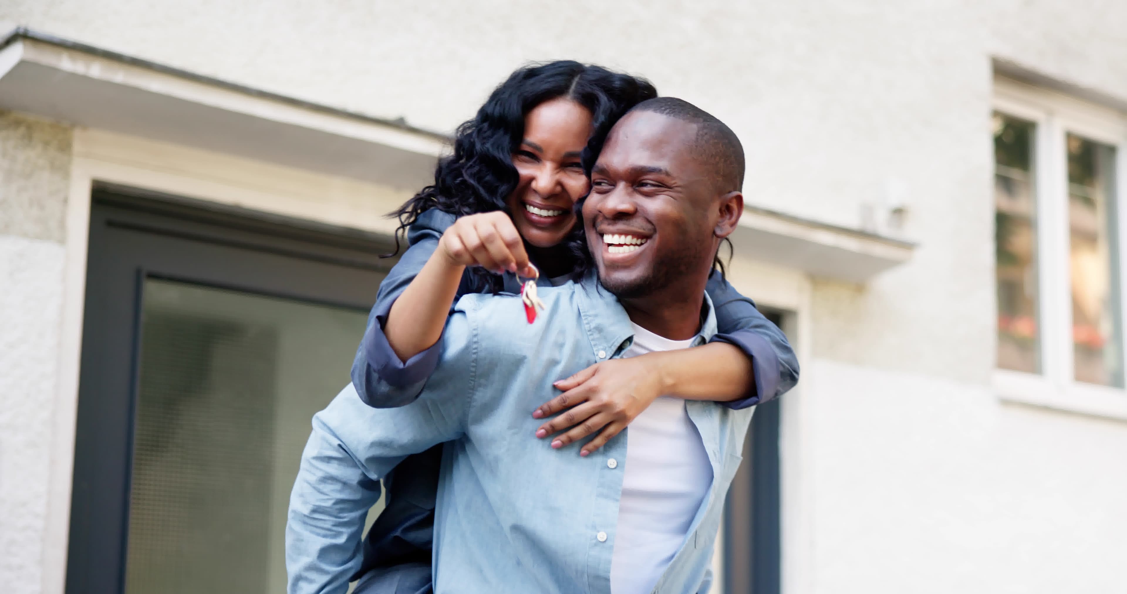 A happy couple holding house keys after building enough equity to remove PMI