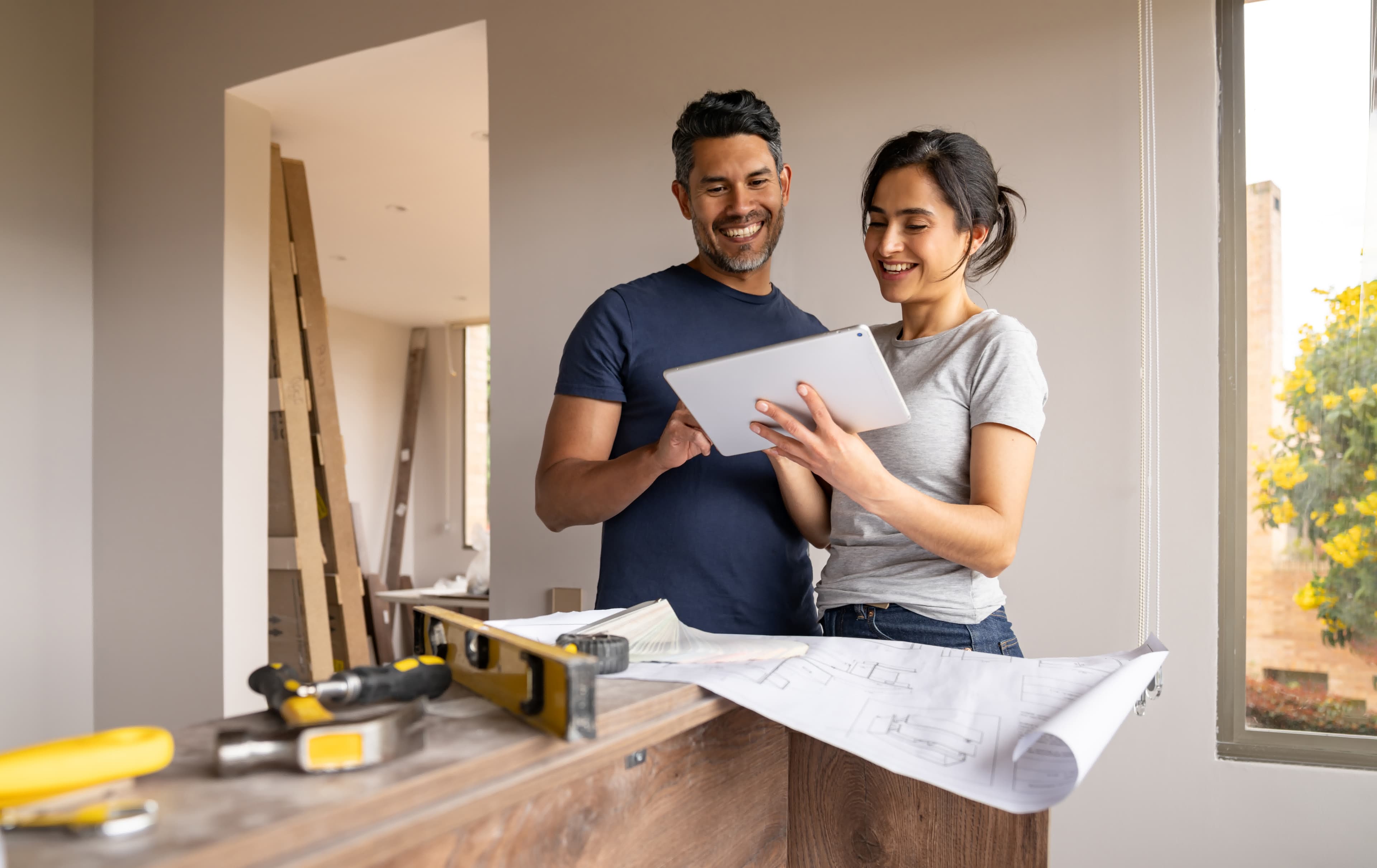 A couple planning a renovation on a tablet using cash from a cash-out refinance