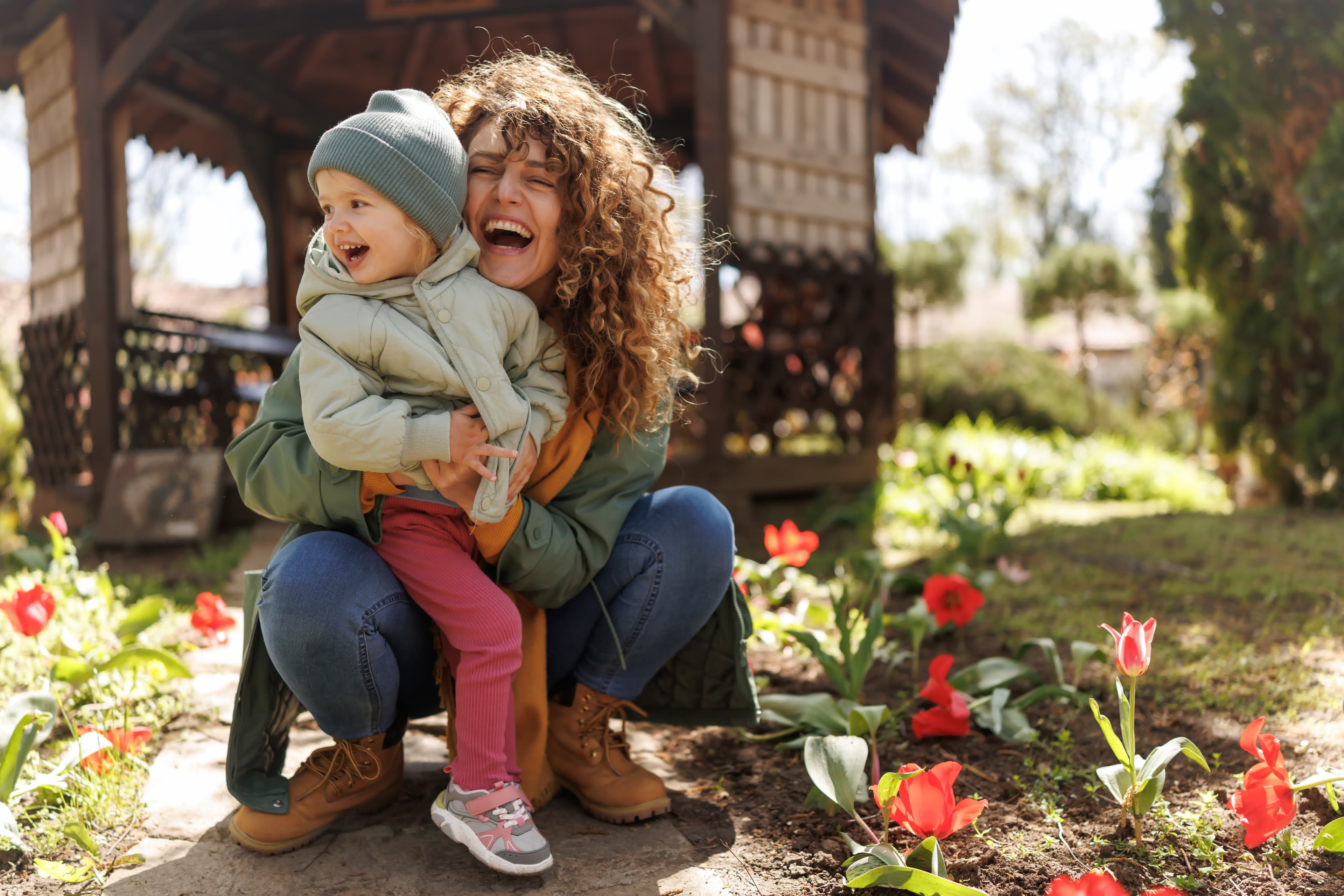 A mother and child in a sunny suburban garden of a USDA-eligible home
